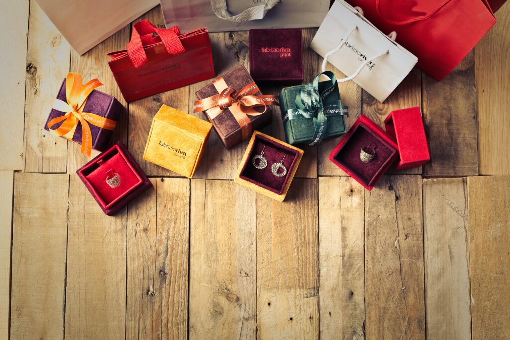 Cadeaux de bijoux élégants avec des sacs de courses sur un plancher en bois, parfaits pour les fêtes de fin d'année.